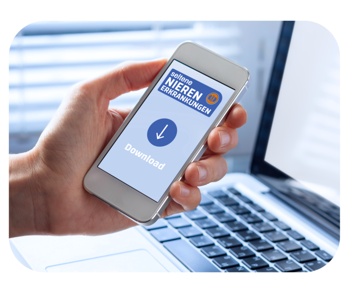 Nützliche Downloads zu seltenen Nierenerkrankungen Eine Hand hält ein Smartphone, auf dem „Downloading“ steht, im Hintergrund ein aufgeklappter Laptop.