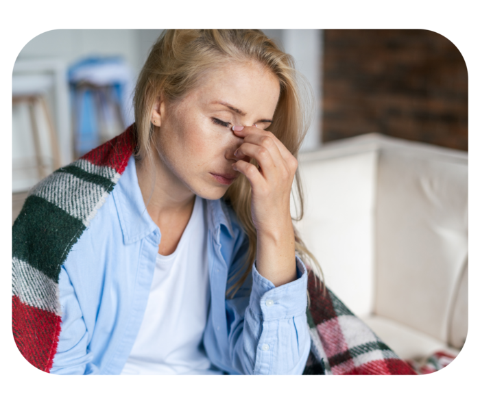 Eine Frau, die erschöpft auf einem Sofa sitzt.