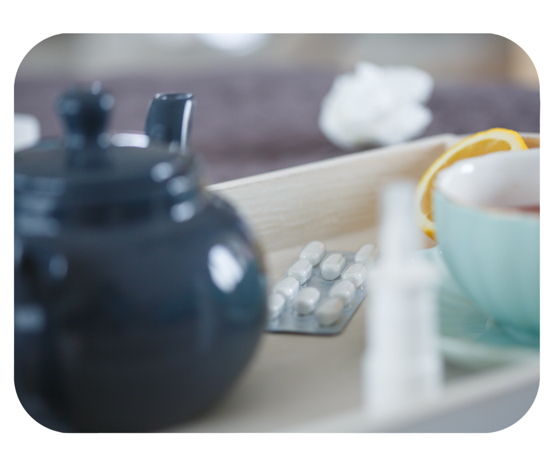 Teekanne, Teetasse, Nasenspray und Tablettenblister.
