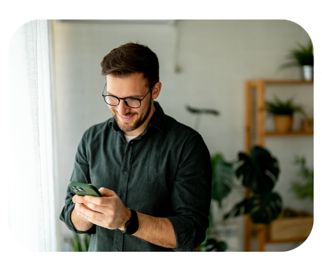 Live-Chat des Medizinischen InfoService Junger Mann schaut auf ein Smartphone, das er in seinen Händen hält.
