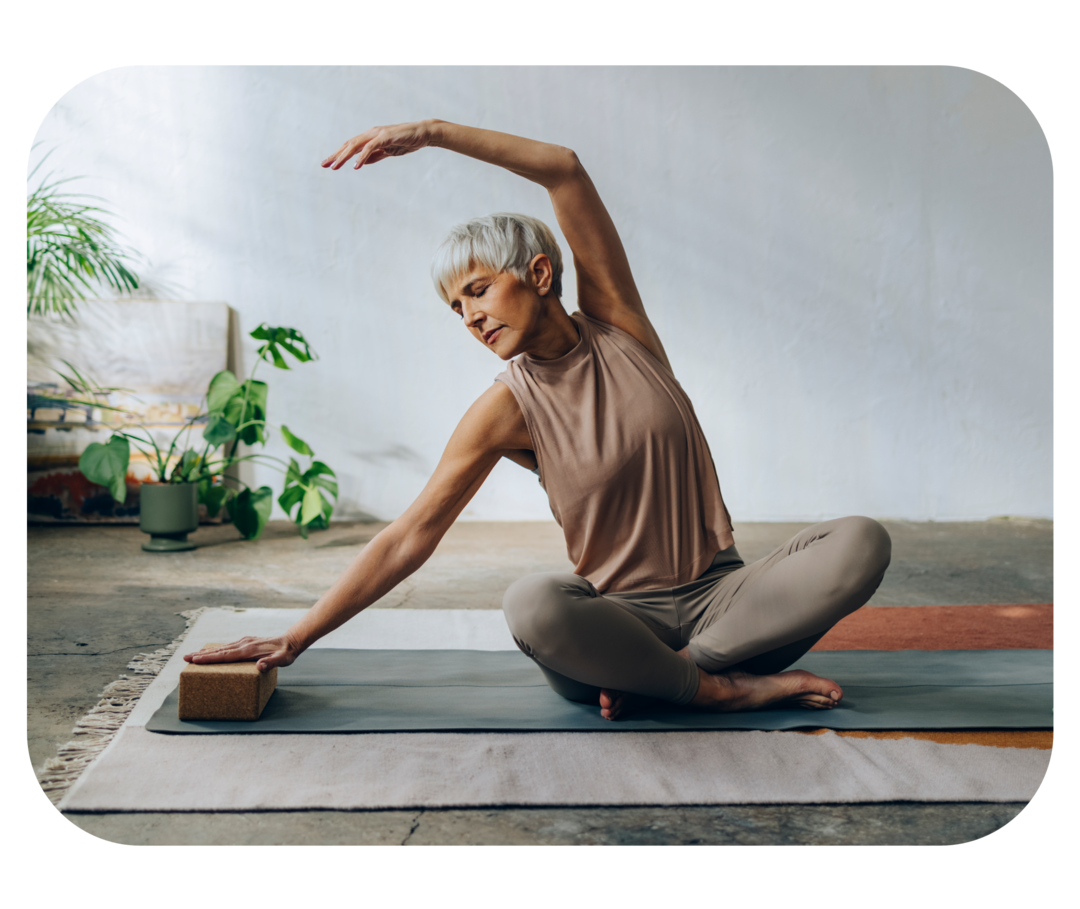 Eine ältere Frau macht Yoga auf einer Matte.