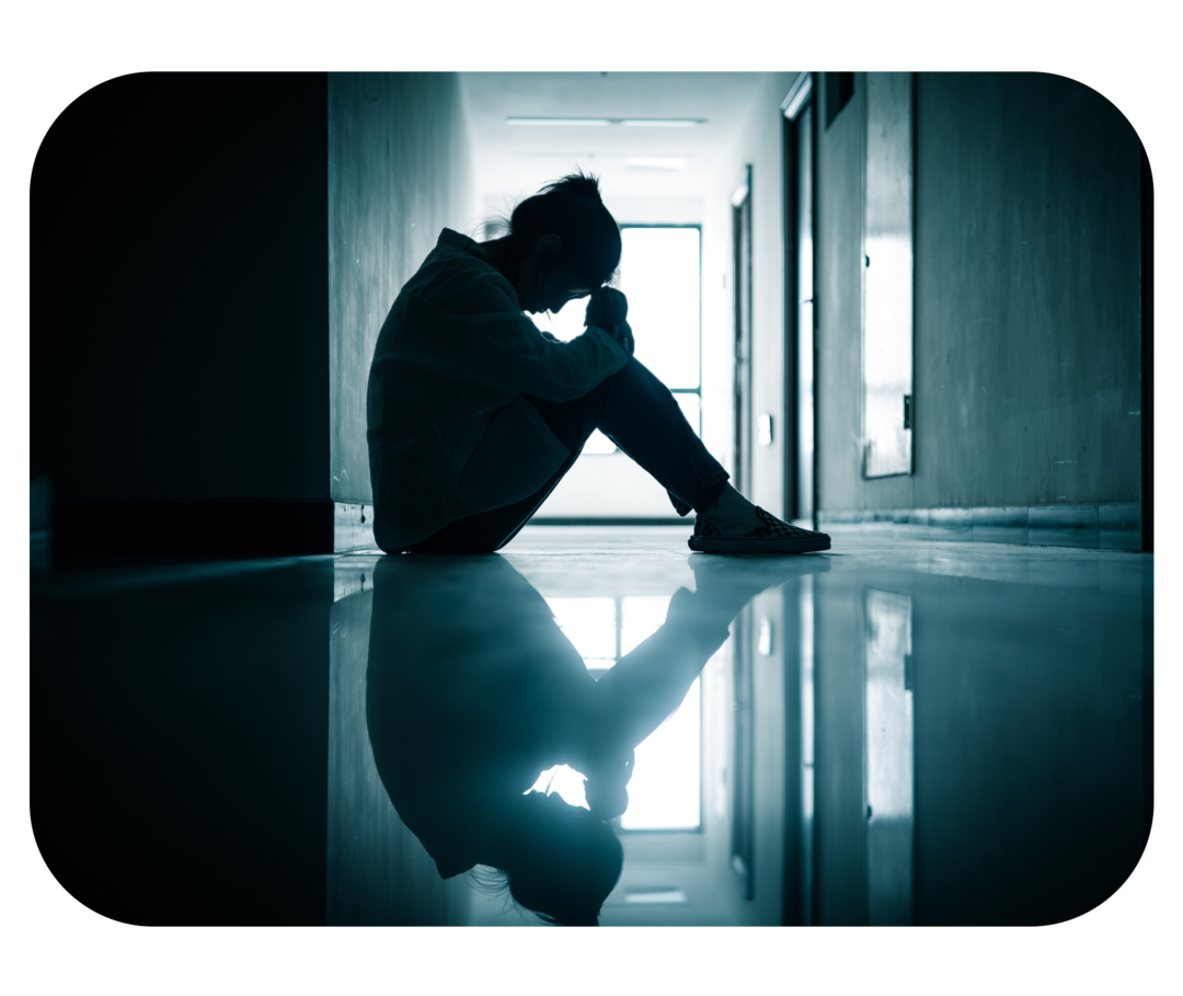 Eine Frau sitzt zusammengesunken in einem Flur