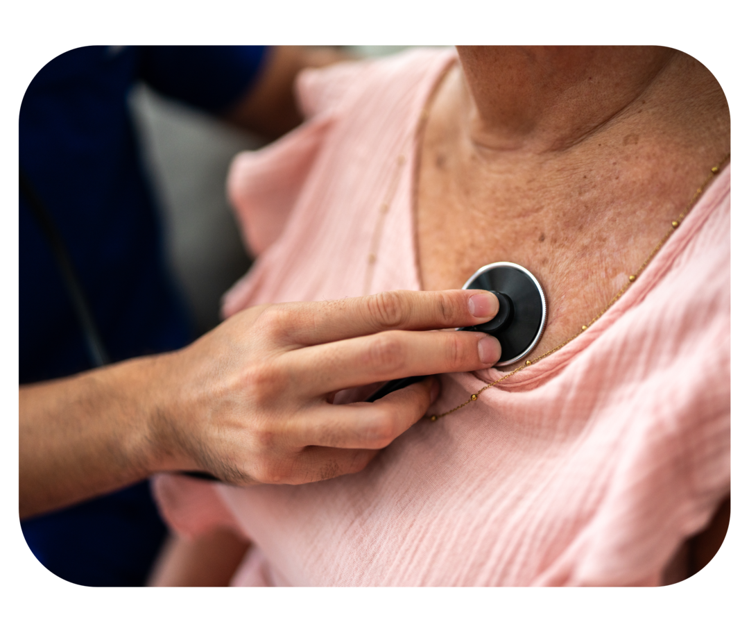 Eine Frau wird mit einem Stethoskop abgehört.