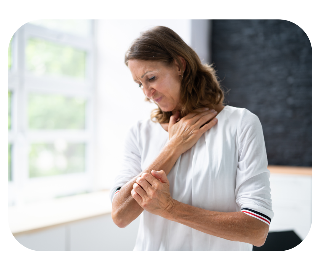 Eine Frau, die sich am Arm kratzt.