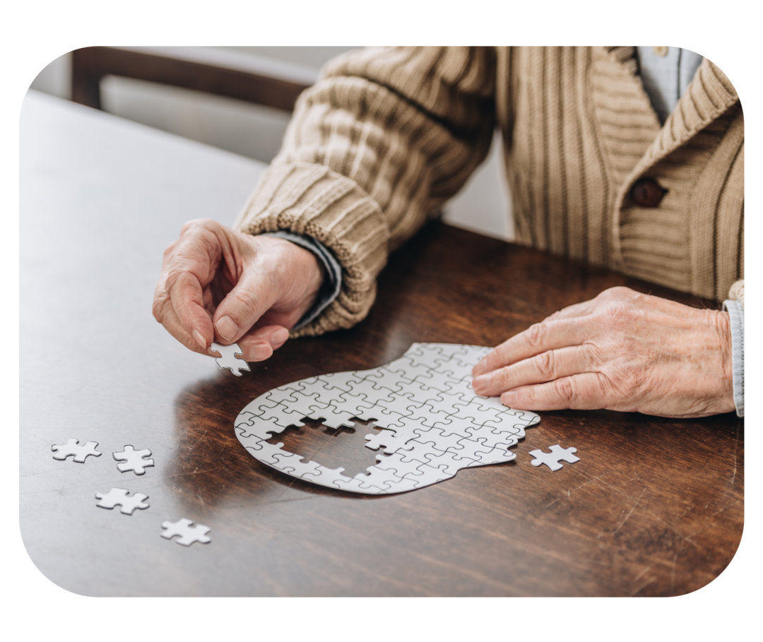 Eine Person legt ein Puzzle in Form eines Kopfes.